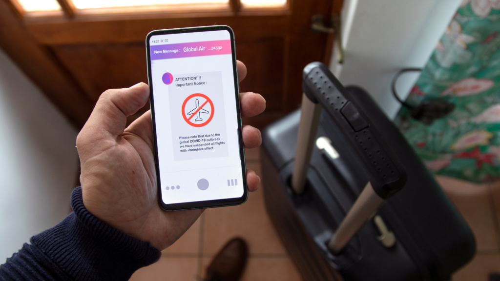 Une personne recevant un SMS indiquant que son vol a été annulé en raison de la COVID-19.